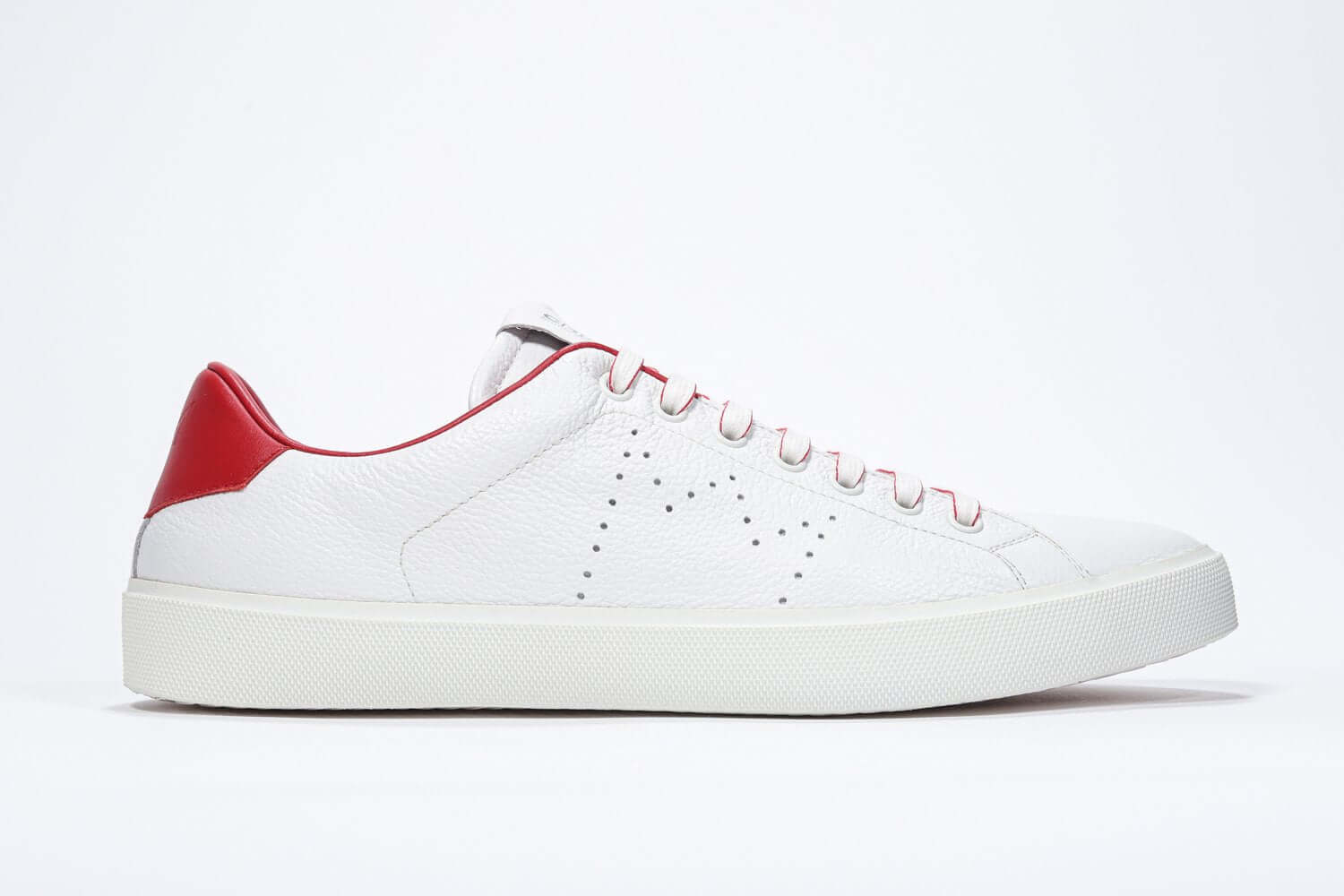 Side profile of low top white sneaker with red detailing and perforated crown logo on upper. Full leather upper and white rubber sole.