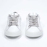 Front view of low top white sneaker with navy detailing and perforated crown logo on upper. Full leather upper and white rubber sole.