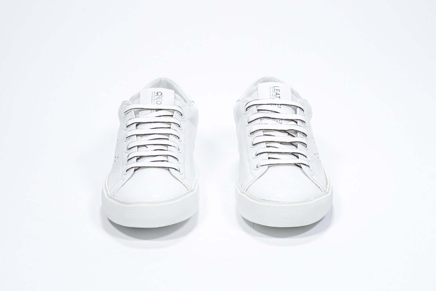 Front view of low top white sneaker with perforated crown logo on upper. Full leather upper and white rubber sole.