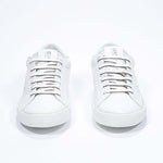 Front view of low top white sneaker with perforated crown logo on upper. Full leather upper and white rubber sole.