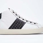 Side profile of mid top white and navy sneaker. Full leather upper with studs, an internal zip and vintage rubber sole.