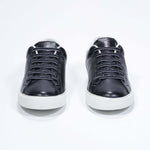 Front view of low top black sneaker with white detailing and perforated crown logo on upper. Full leather upper and white rubber sole.