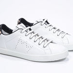 Three quarter front view of low top white sneaker with leopard print detailing and perforated crown logo on upper. Full leather upper and white rubber sole.
