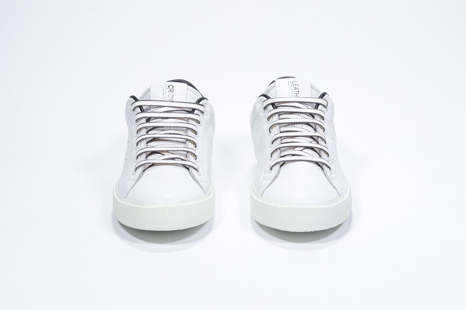 Front view of low top white sneaker with leopard print detailing and perforated crown logo on upper. Full leather upper and white rubber sole.