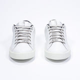 Front view of low top white sneaker with leopard print detailing and perforated crown logo on upper. Full leather upper and white rubber sole.