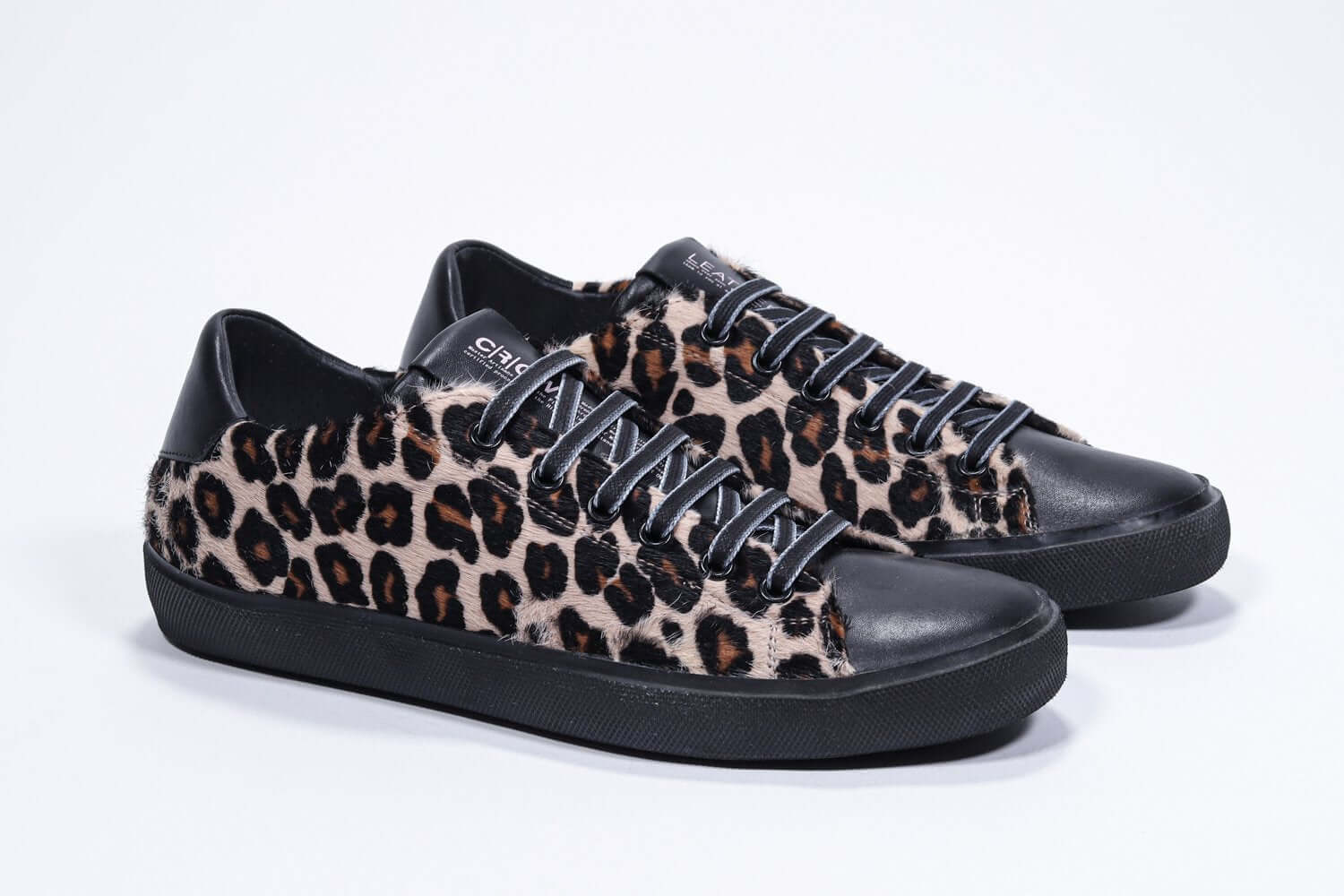 Three quarter front view of low top leopard print sneaker. Full haircalf leather upper and black rubber sole.