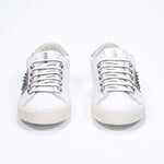 Front view of low top white and metallic rose sneaker. Full leather upper with studs and vintage rubber sole.